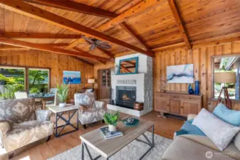 Bam! Round the corner to the other side of the house, and THIS awaits.  Breathtaking room, out of a magazine. Knotty pine walls with wood beam vaulted ceiling and generous, wood burning stone fireplace....all the goodies!