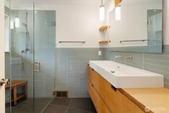 The midcentury modern detailing comes alive in the thoughtful remodeled primary bathroom, with enticing tile details and updated fixtures.