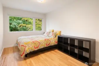 The second bedroom on the main floor is spacious and the beautiful window of trees as an added bonus.