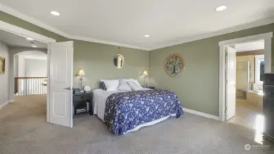 A luxurious master bedroom with a direct sightline into the spa-like master bath.