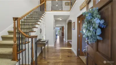 Stunning hardwood floors and rich wood accents, even down to the staircase handle, create a warm and inviting ambiance.