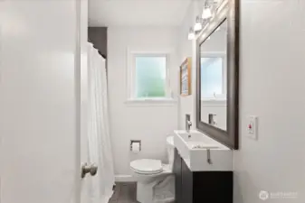 The hall bath offers a clean, modern design with updated fixtures and natural light
