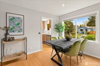 The dining area captures leafy neighborhood scenes through oversized windows and connects easily to the updated kitchen.