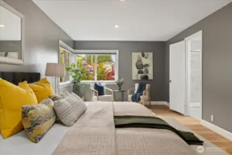 Oversized windows and a warm color scheme make this primary suite as inviting as it is spacious.