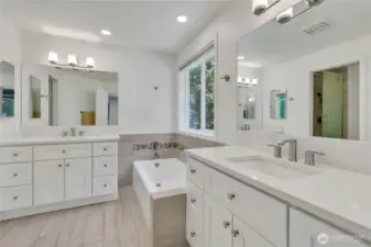 Luxurious primary bath with dual vanities, soaking tub, and separate shower.