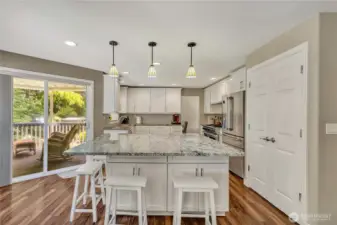 The gourmet kitchen is a chef's paradise. Sliders lead to a covered deck for seamless indoor-outdoor living.
