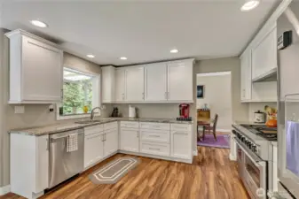 Stainless steel appliances including a Wolf 6-burner double oven range and white cabinetry add to the appeal of this kitchen.