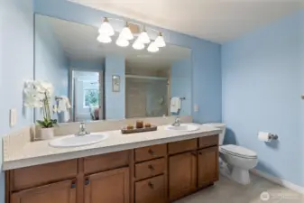 The luxurious primary bathroom has tile floors, double-sink vanity, and it's own linen closet.