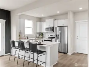 Alternate angle spotlights subway-tile backsplash, pantry storage and wide plank flooring flowing into dining. Pictures are for representational purposes only, colors and features may vary.