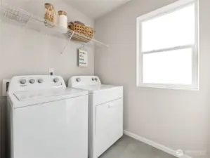 Light-filled upstairs laundry features Whirlpool washer and dryer, durable flooring, and a full-length wire shelf to keep supplies tidy. Pictures are for representational purposes only, colors and features may vary.