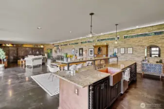 Large countertop with large copper farm sink and breakfast bar.