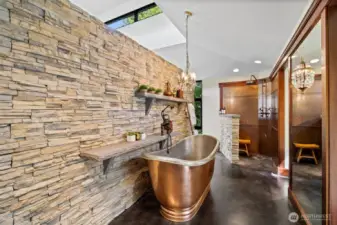 Another view of primary bath with copper soaking tub, and stone wall.