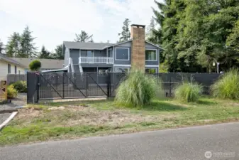 view from the street showing the fenced in area with a manual gate as well as a electric gate.