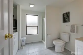Downstairs bathroom with a walk in shower and washer and dryer.