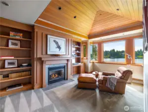 Relax in the study, where oak cabinetry, vaulted hemlock ceilings and a cozy fireplace frame stunning lake views