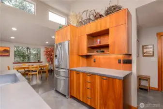 Deep wood grain, stone counter top tile, built in floating shelves, give permission for less clutter and mental clarity.