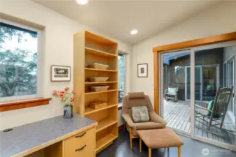 The office features a built-in wraparound workspace and shelving, seamlessly integrated to create a functional and thoughtfully designed work area.