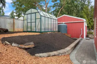 Greenhouse, 1,000 gallon rainwater storage tank, and the large garage with workshop! Garage is wired and ready for a 220v EV charger.