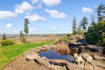 Serene backyard with pond and waterfall. Incredible views of Cascade Mountains, the Orting Valley, Orting's High Cedars Golf Course, and the hawks soaring through the trees.