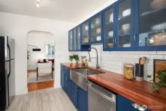 Kitchen view into living room with curved doorway and lots of cabinets