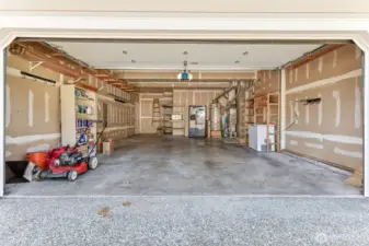 Large, oversized 2-car garage with bump out extra storage, drywalled / insulated. Includes additional stainless steel refrigerator & freezer, lawnmower and household paint/supplies for new owner.