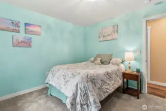 First bedroom overlooks front yard through gridded windows bordered by flower boxes.