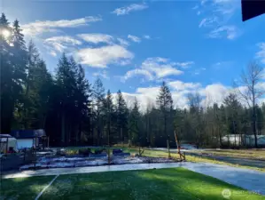 View of the back yard and forest from the deck in the winter time.