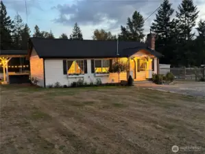 Front yard at twilight.  Deck with hot tub on concrete slab on the east side.
