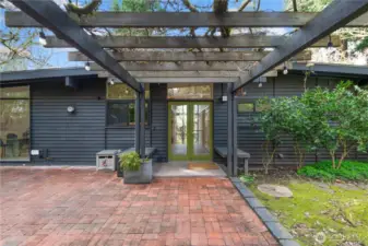 Inviting entry with classic French doors opens into a light-filled interior. Large opposing windows flood the home with natural sunlight, creating a warm and welcoming first impression.