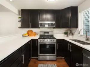 The updated kitchen shines with sleek quartz countertops, a gas cooktop, stainless steel appliances, and trendy design details that elevate everyday living and entertaining.