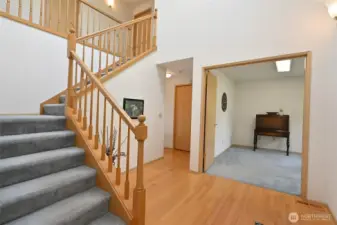 Carpeted stairs to upper level with den/office off the entry