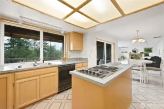 Maple cabinetry and island cooktop, with good storage opens to informal dining area and the family room