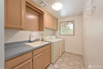 Laundry room next to garage door has utility sink, good storage, and full size W/D