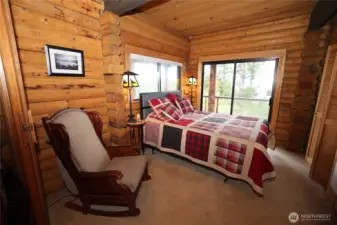 Spacious bedroom with wood accents and natural light, designed for comfort and simplicity.