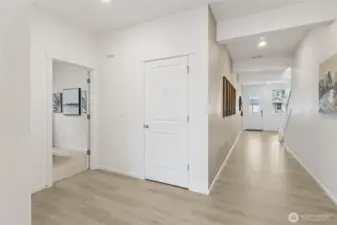 Wide hallway leading you to the downstairs bedroom.   Pictures are for representational purposes only, colors and features may vary.