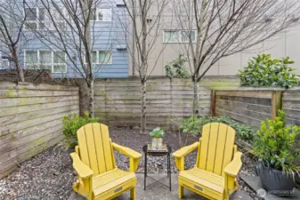 Backyard features a patio and an area for gardening and pots.