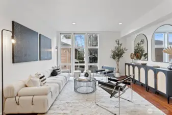 Large floor-to-ceiling windows and high ceilings bring in lots of light to this spacious living area.