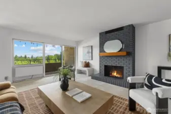 Grounded by a charcoal brick hearth and framed by greenery, the living room offers a calm, elevated space to unwind indoors or out. The glow of the fireplace adds just the right touch of comfort.