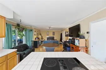 Here's a photo from the kitchen facing the large fireplace.  You can see that there is a lot of space that can be used in many different ways.  The Bay windows and glass sliders are on the left.  That white door at the end on the right goes to the oversized 2 car garage.  The Sellers have set up this room to accommodate their family with a study desk and couch on the left, a large TV and second desk on the right.  This room can be configured in so many ways!