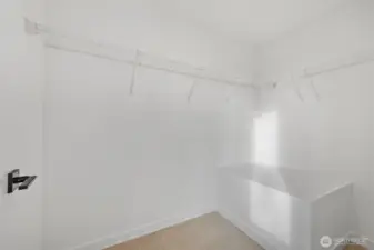Primary suite walk-in closet.   Photos are of model home of same floorplan. Color schemes will vary.
