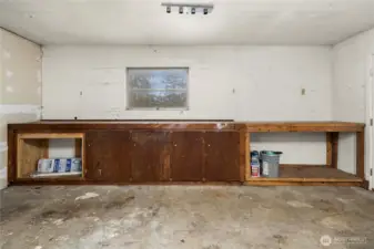 Interior garage workspace offers built-in shelving and counter space, ideal for hobbies, projects, or storage needs.