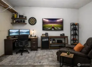 Garage flex space is currently set up as a home office or man cave, offering a versatile option for work or recreation.  (photo virtually staged)
