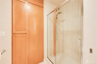 A close-up to the tile shower and additional storage.
