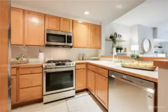Wonderful kitchen with gas cooking, stainless steel appliances and plenty of counter and lovely wood cabinets for storage plus raised eating bar.