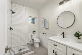 Beautiful main level ¾ guest bath is all decked out with handsome tiling and a one-of-a-kind shower surround.