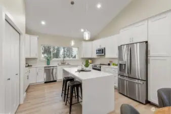 Gather at the breakfast bar, outfitted in stunning waterfall quartz, awash in the glow of glass pendant lighting.