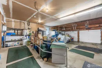 Inside of attached 2 car garage,  Concrete ramp leads into the house. Generator with separate panel stays.