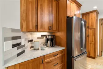 Beautiful bright kitchen with gorgeous Pecan cabinetry, stainless steel appliances, quartz counters and tile backsplash.