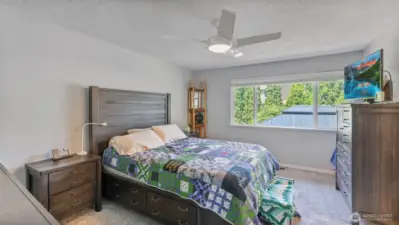 The primary bedroom offers natural light, generous open space, and direct access to a private en suite bathroom