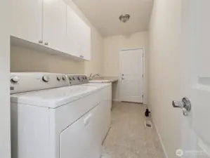 Laundry/mud room complete with sink and plenty of extra storage. Door leads out to your two car garage.